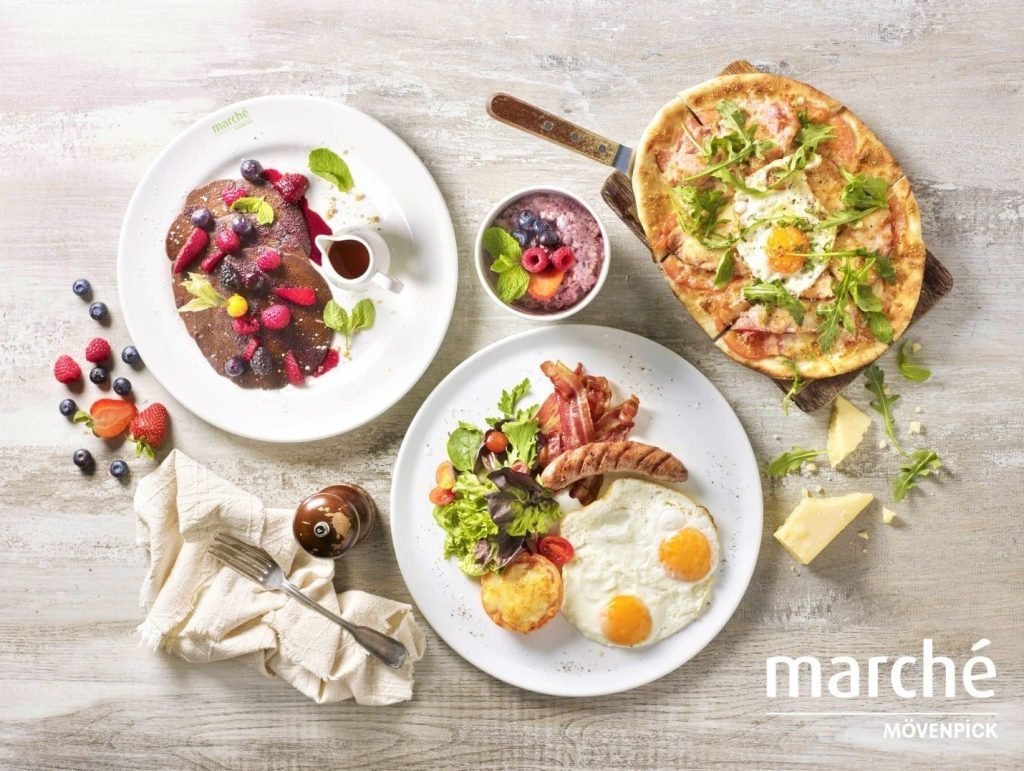 A brunch spread from Marché Mövenpick VivoCity, including pancakes, a breakfast platter, and pizza