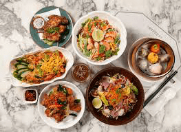 A top-down flat lay of various Asian-inspired dishes from Chopsuey Cafe