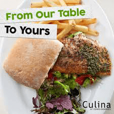 A close-up of a meal from Culina at COMO Dempsey: a sandwich in a square ciabatta-style bun with a herb-crusted fillet