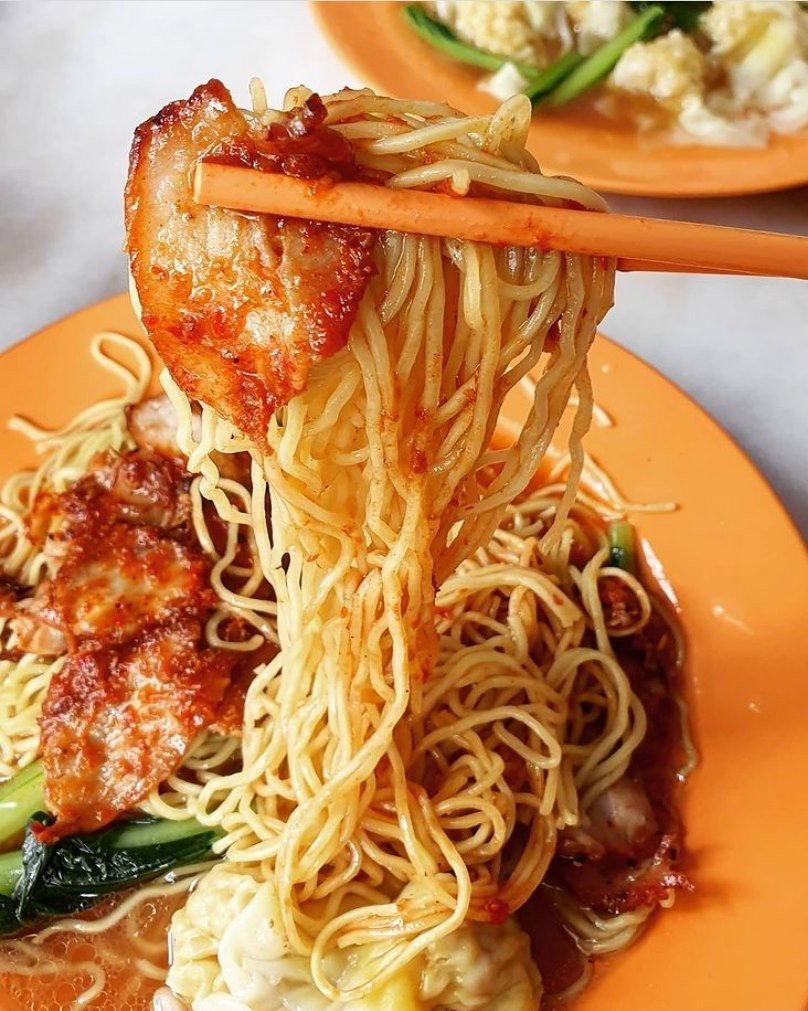 A close-up of Kok Kee Wonton Noodle being lifted by chopsticks