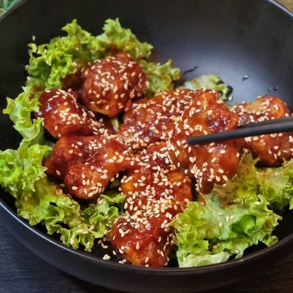 A bowl of sweet and spicy vegetarian "chicken" with sesame seeds from New Fut Kai Vegetarian Restaurant