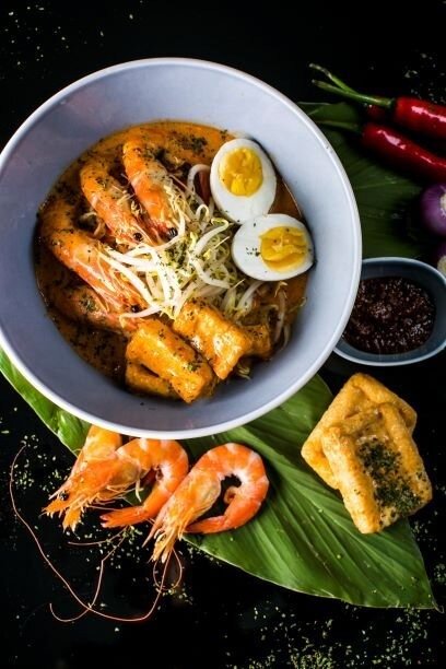 Artistically plated prawn laksa from OPIO Kitchen & Bar, served in a light blue bowl