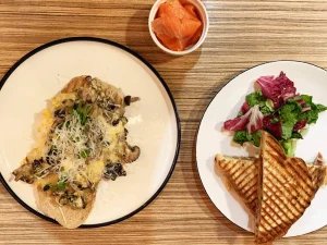 refuel cafe - scrambled eggs with mushrooms and grated cheese on toast, a side of smoked salmon in a small bowl