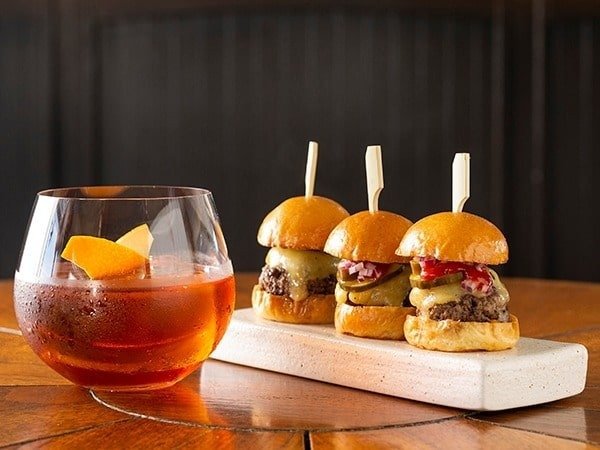A Negroni cocktail served with three beef sliders at Spago Dining Room