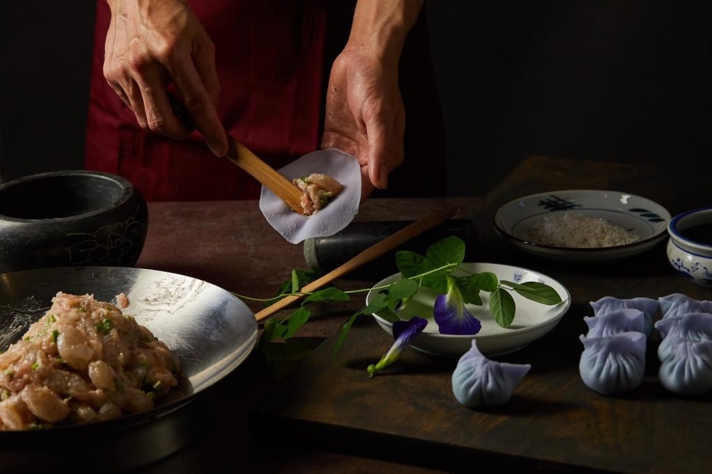 A chef at Sum Dim Sum preparing signature butterfly pea flower dumplings by hand