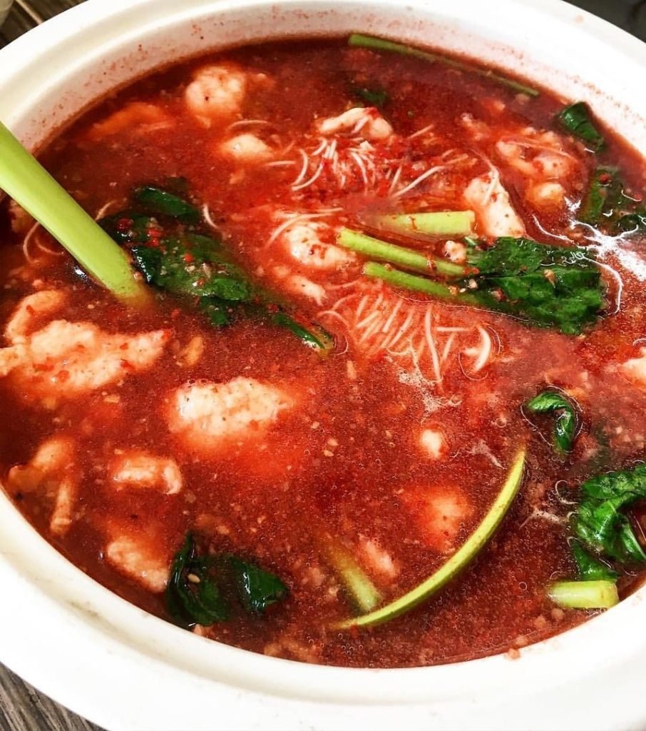 Close-up of a vibrant red noodle soup from 99 Buona Vista Kitchen