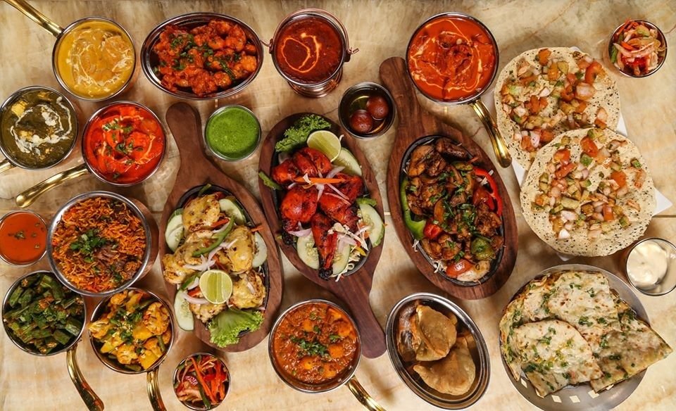 An elaborate overhead shot of an Indian food feast from Barrels on a marble tabletop.