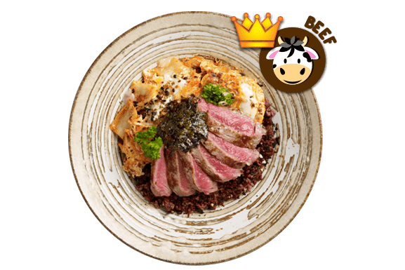Close-up top view of a rice bowl with slices of seared beef, kimchi with egg, dark grains, and seaweed paste