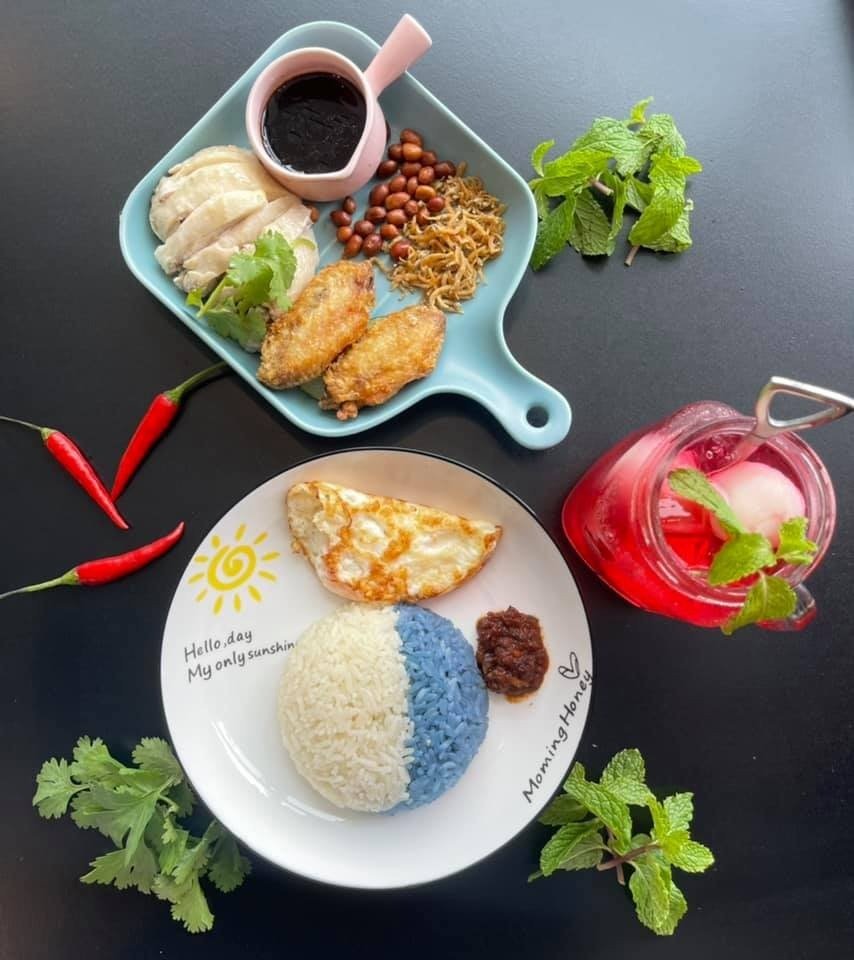A beautifully plated Nasi Lemak set from Colourful Day Cafe on a black table.