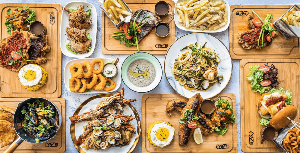 Overhead view of a large, diverse food spread from CRAZE restaurant