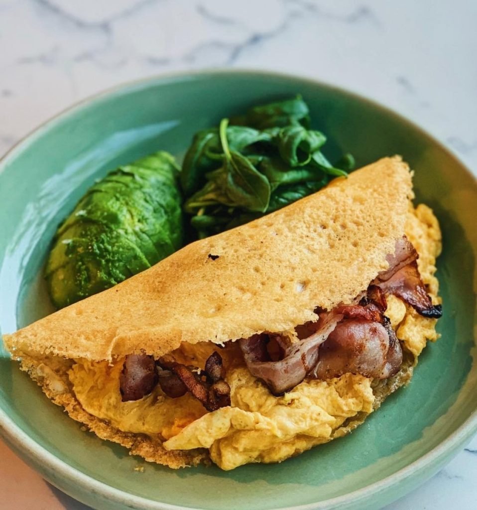A keto-friendly crepe from Da Paolo Dempsey Restaurant & Bar, filled with scrambled eggs and crispy bacon, served in a light green bowl