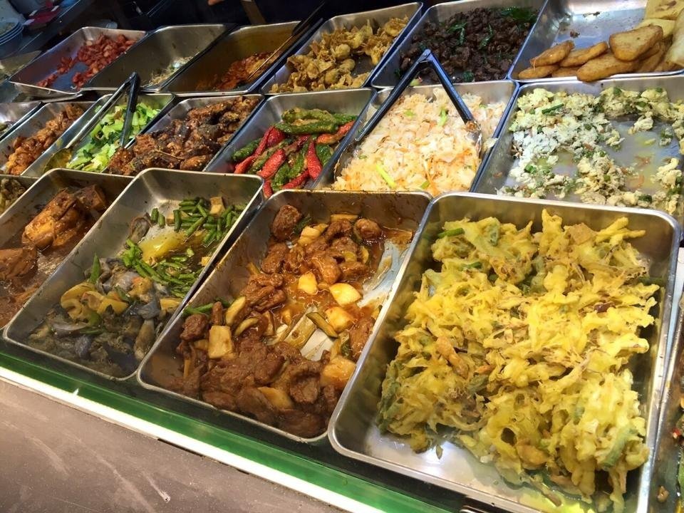 Buffet-style display of various vegetarian dishes in stainless steel trays at Eight Immortals Vegetarian