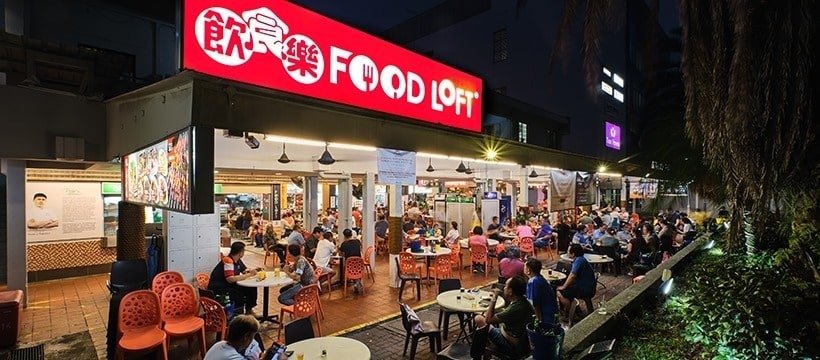A lively night scene at Food Loft, a popular food court filled with diners