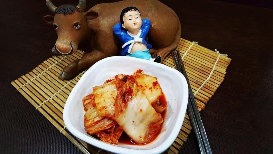 Close-up of a serving of traditional Korean kimchi in a white square bowl