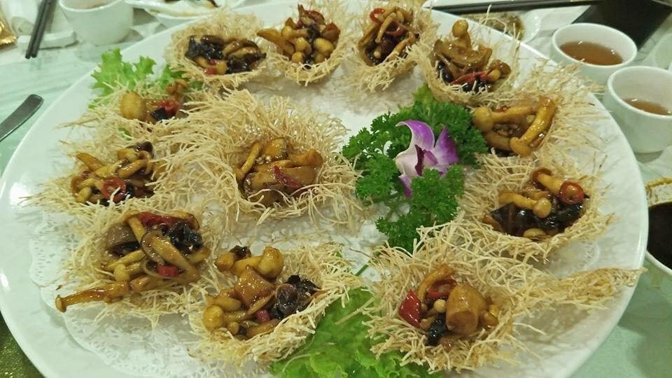 A large white serving platter from Miao Yi Restaurant featuring numerous individual crispy fried noodle or taro nests.
