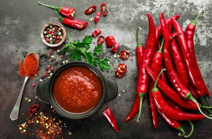 a picture of red chili peppers and paste with spices