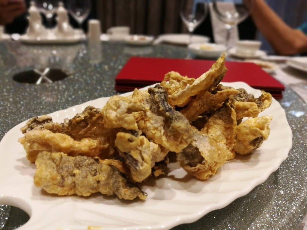 Close-up of a serving of crispy fried fish skin on a white plate