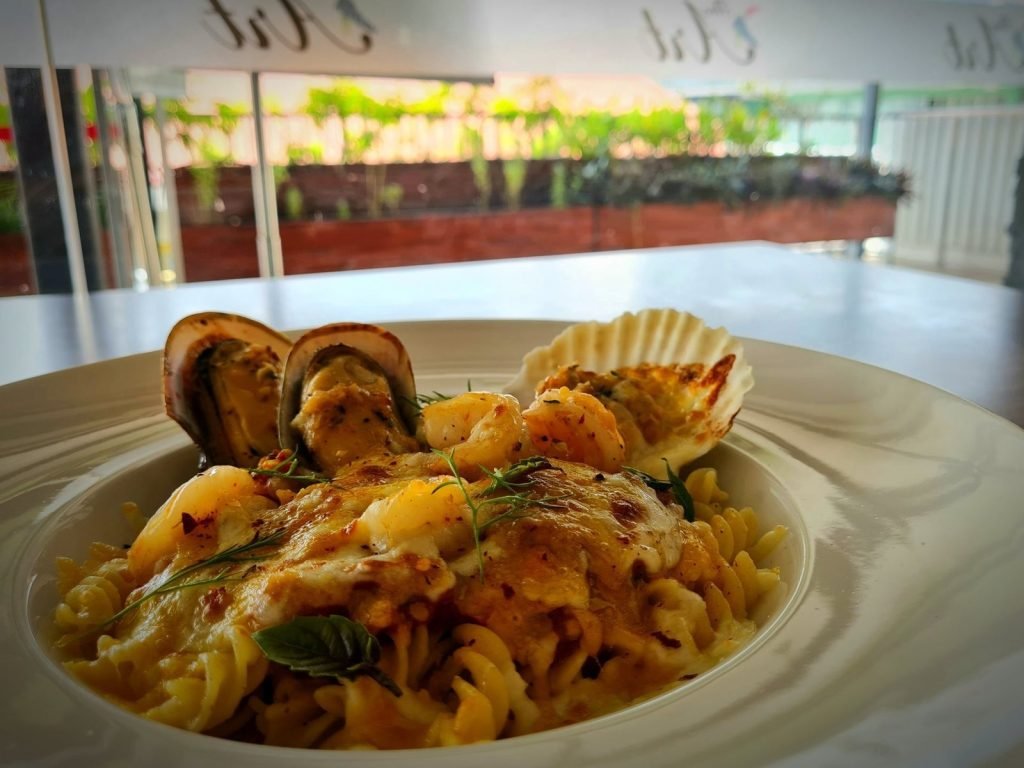 Baked seafood fusilli pasta with mussels, prawns, and scallop in a creamy cheese sauce.