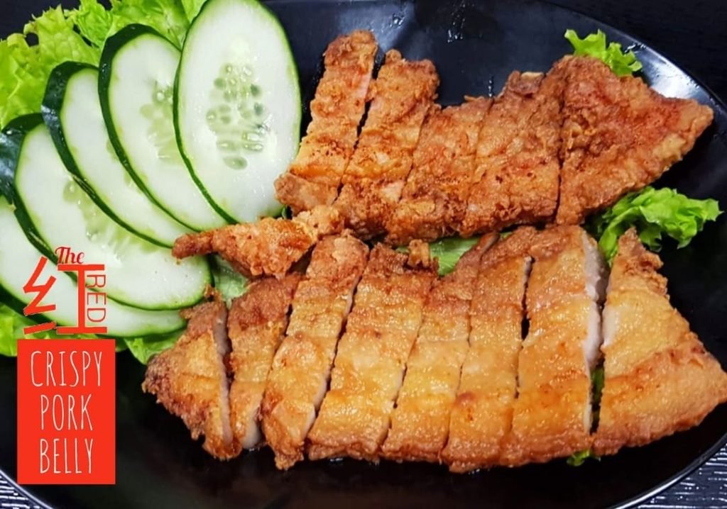The 'RED CRISPY PORK BELLY' featuring sliced crispy pork belly with cucumber and lettuce garnish