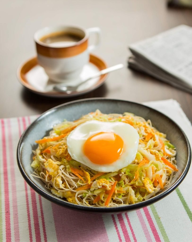 bowl of fried bee hoon (rice vermicelli) mixed with shredded cabbage, carrots, and scrambled egg