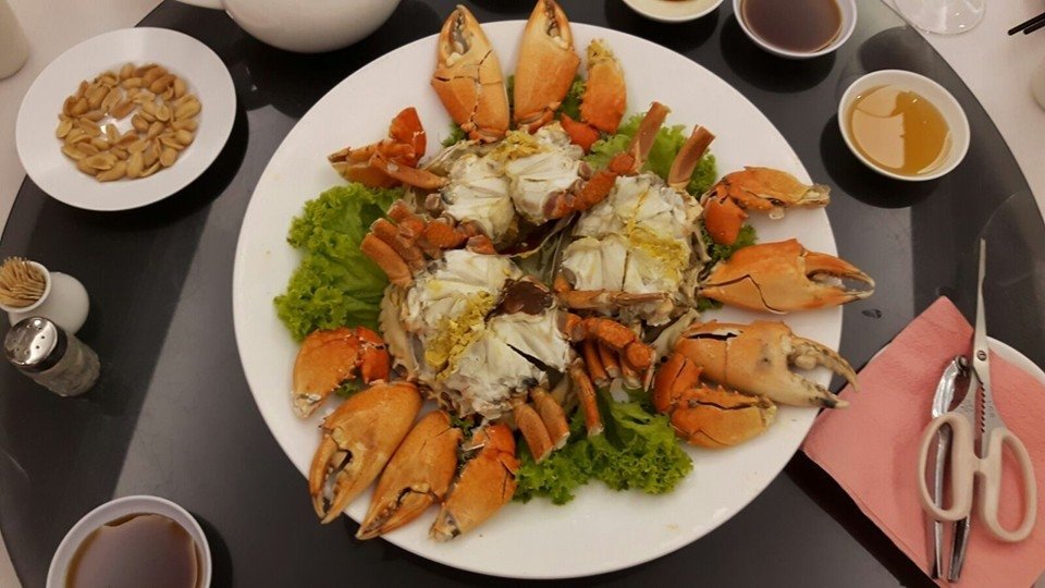 Top-down view of a dining table at Yuan Xing Chaozhou Restaurant featuring a large platter of steamed crabs