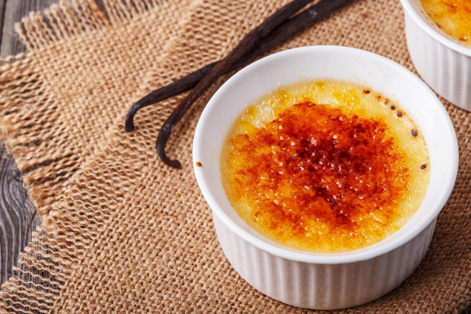 A classic Crème Brûlée in a white ramekin with a caramelized sugar top
