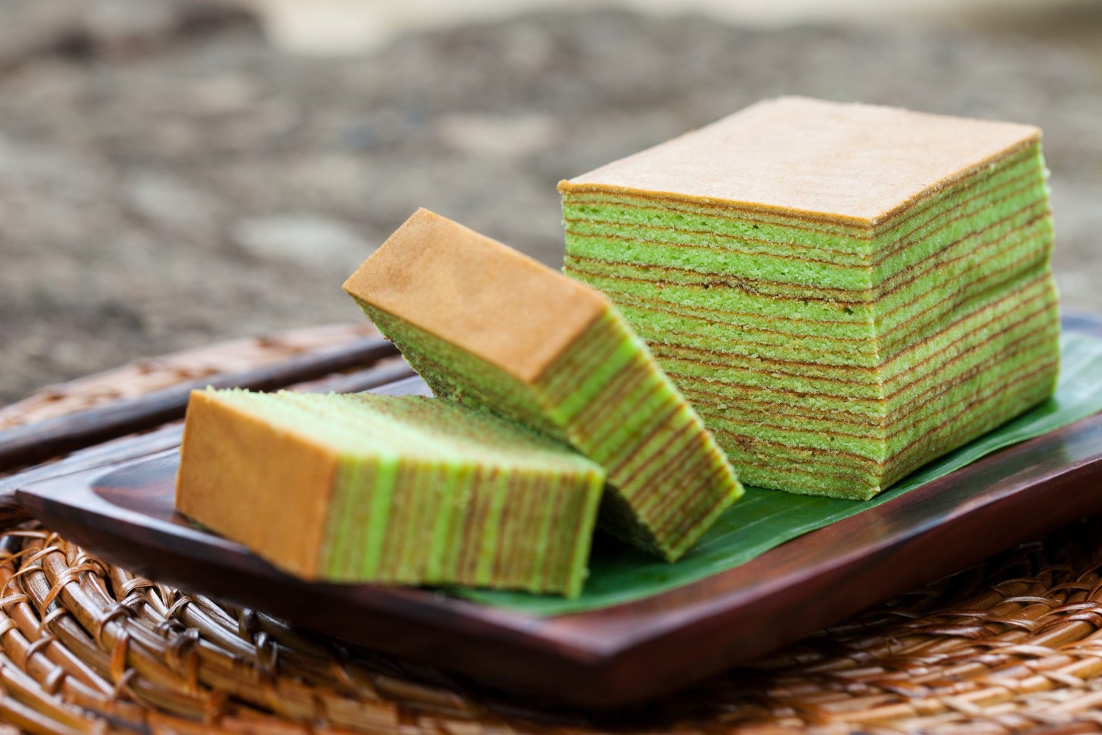 A block and two slices of pandan Kueh Lapis