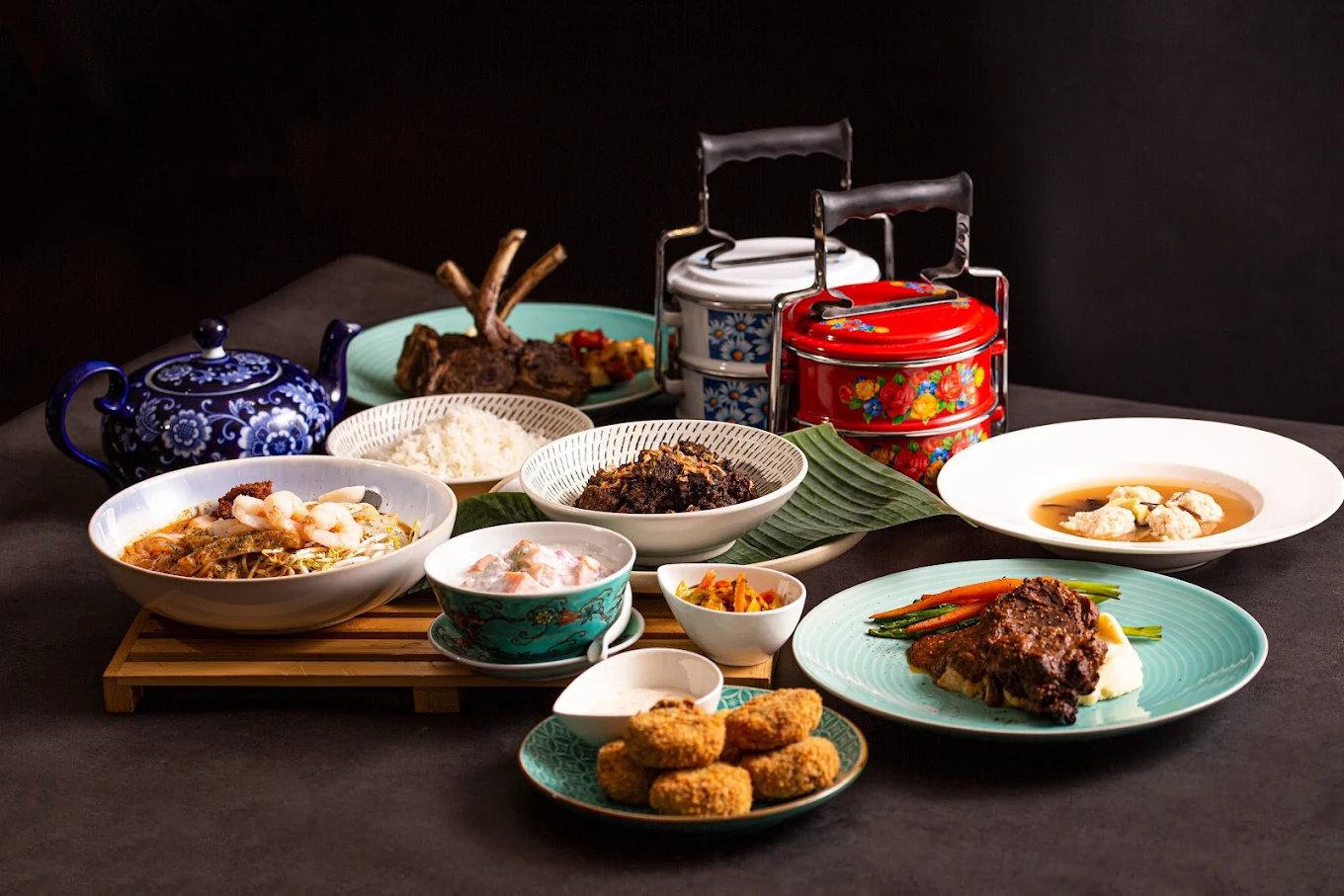 A large, colorful spread of various Peranakan dishes from Nyonyas & Gentlemen restaurant