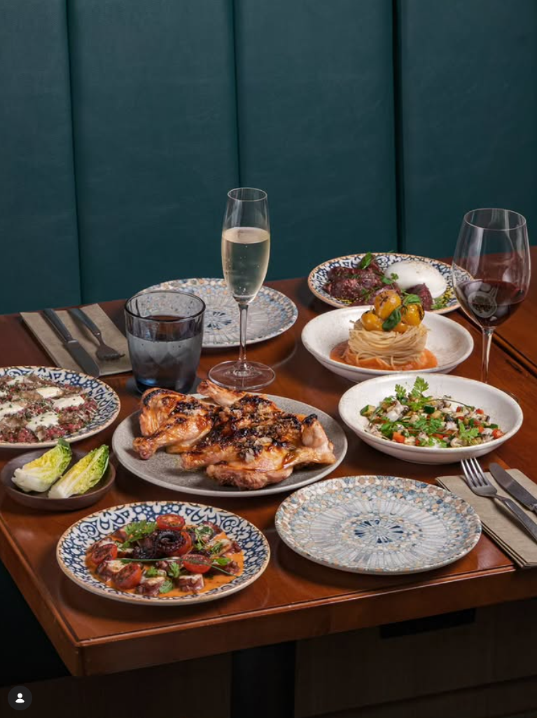 Top-down view of three artisanal Neapolitan-style pizzas with charred, bubbly crusts on a marble tabletop