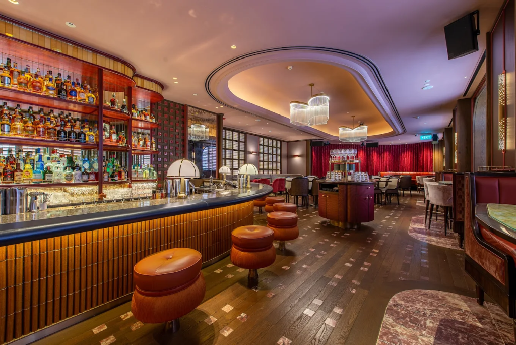 A luxurious curved bar counter with warm amber lighting at Quaich Bar Wanderlust