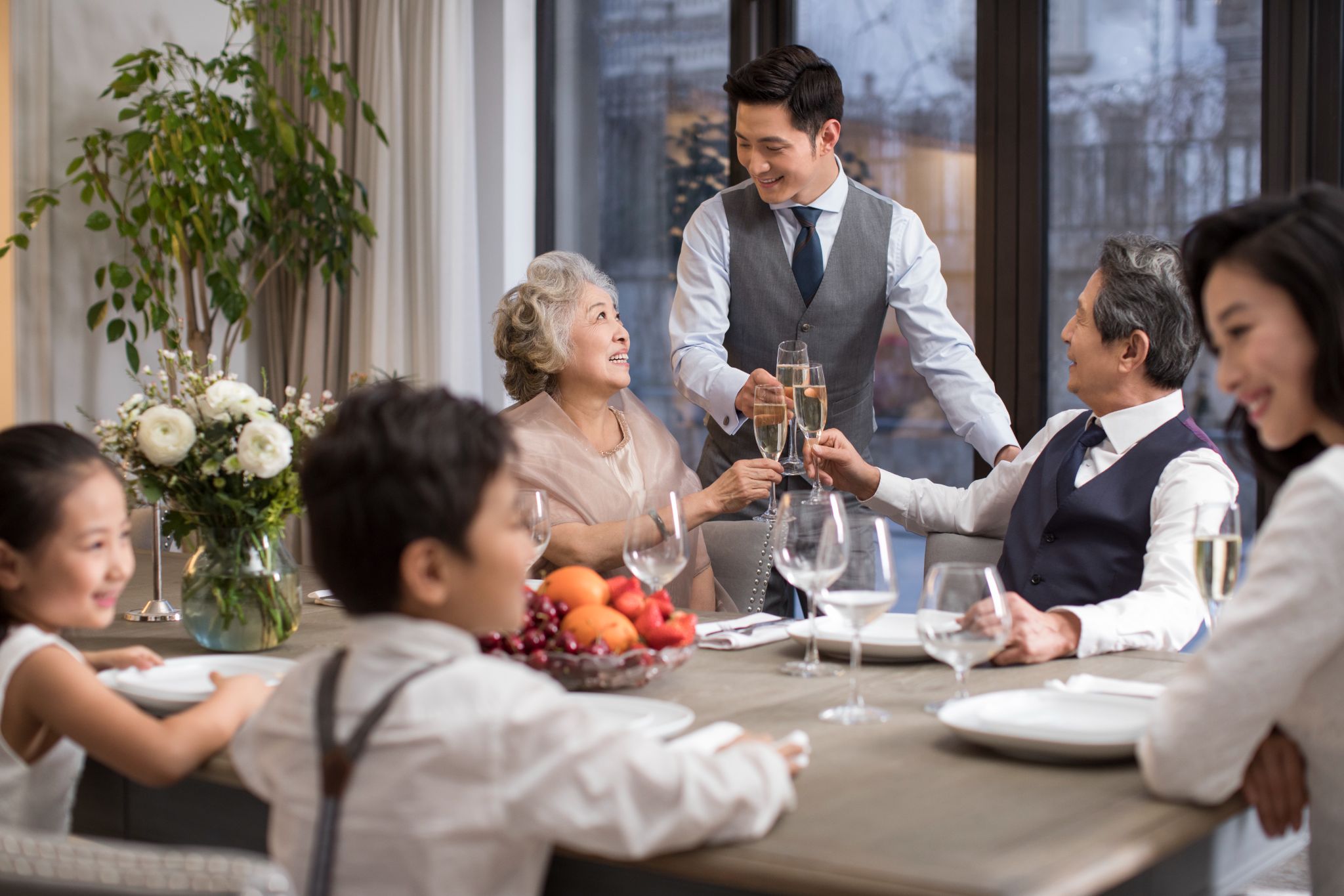a waiter serving a table full with people