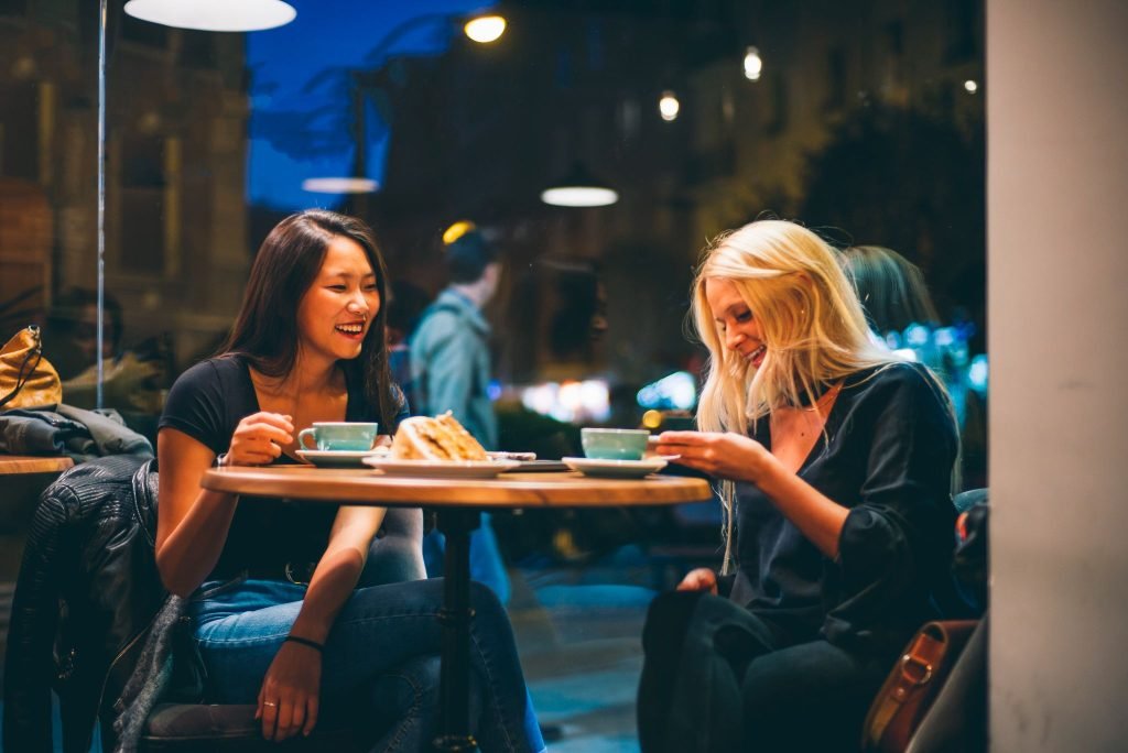 two women happily chatting while having a coffee together