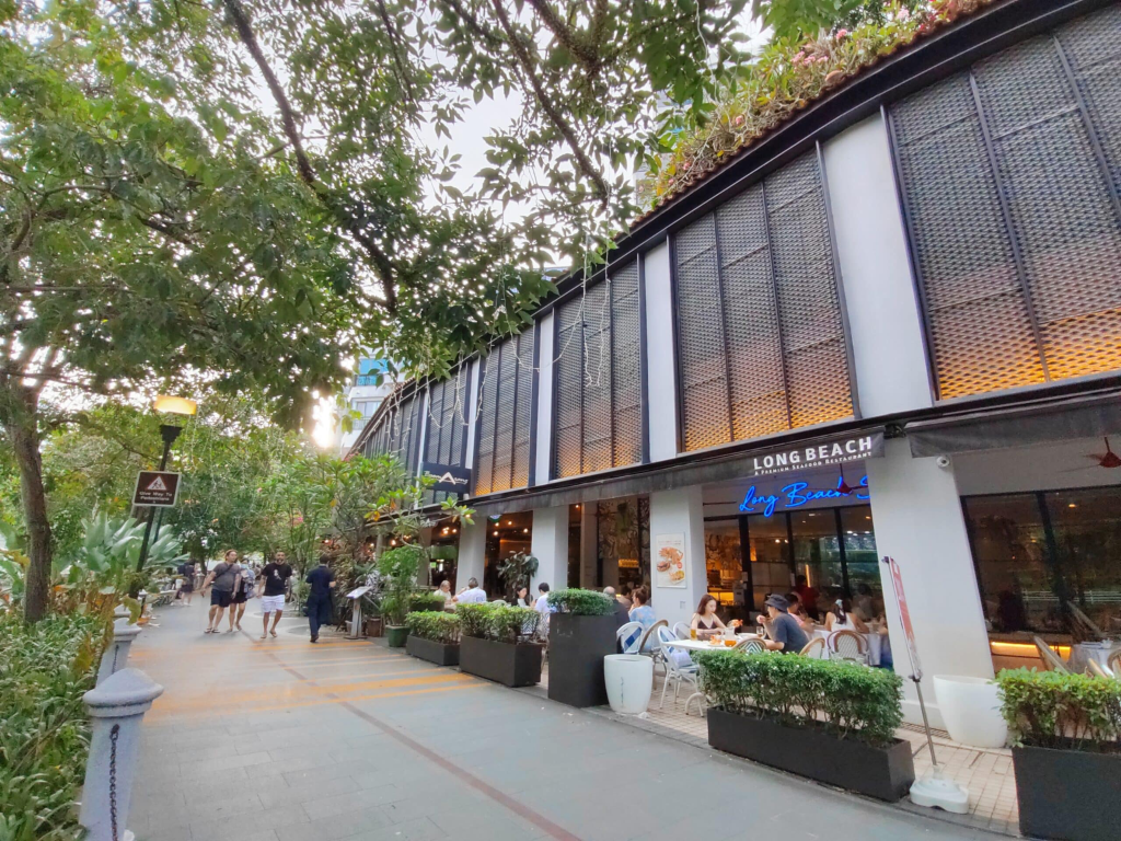 Outdoor dining patio outside Long Beach Seafood Restaurant along a tree-lined walkway