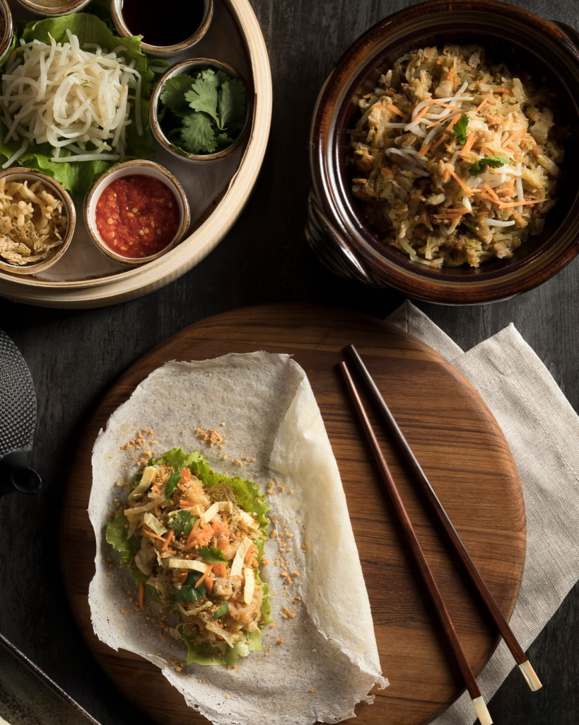 Fresh handmade popiah wrapper with fillings, sauces, and chopsticks at Po Restaurant