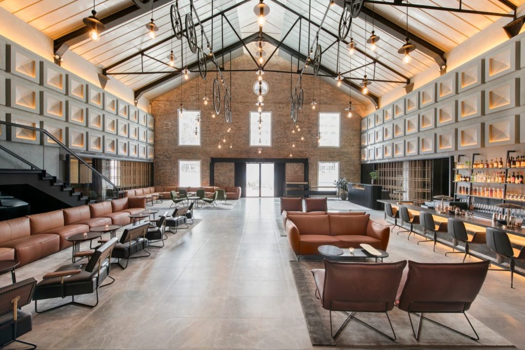 Spacious industrial chic hotel lobby and bar lounge with high gabled ceiling